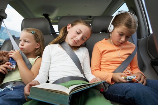 Three girls (6-8 years) on rear car seat, close-up