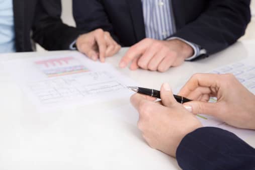 Insurance agent explains the coverage of the policy to a couple clients.